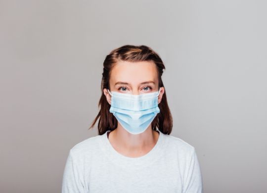 woman-in-grey-sweater-wearing-disposable-face-mask